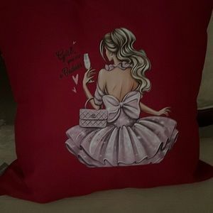 Two decorative pillows, lady dress with white pillow, wet handbag, and heels,